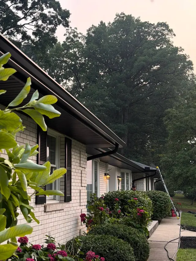 Bronze seamless gutters installed on a white brick ranch home in Bucks County