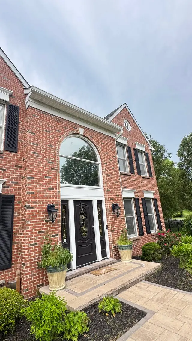 New seamless white gutters on a brick colonial home in Bucks County