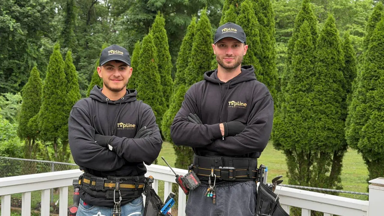 TopLine Gutters crew of two installers in branded hoodies and tool belts in Bucks County, PA